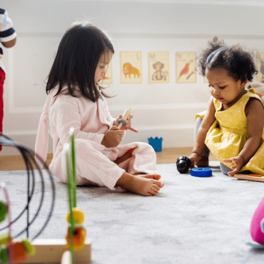 A group of children playing with toys in a playroom.